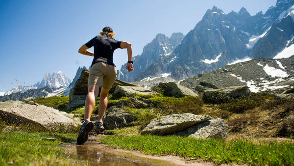 Woman wearing a SuB Zero Factor 1 plus short sleeve thermal base layer in black whilst running in the mountains