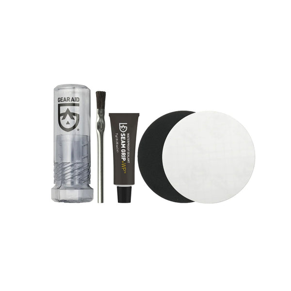 Contents laid out on a white background of Gear Aids Seam Grip waterproof field repair kit