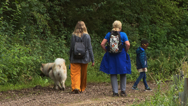 Family walking their dog along a forest path