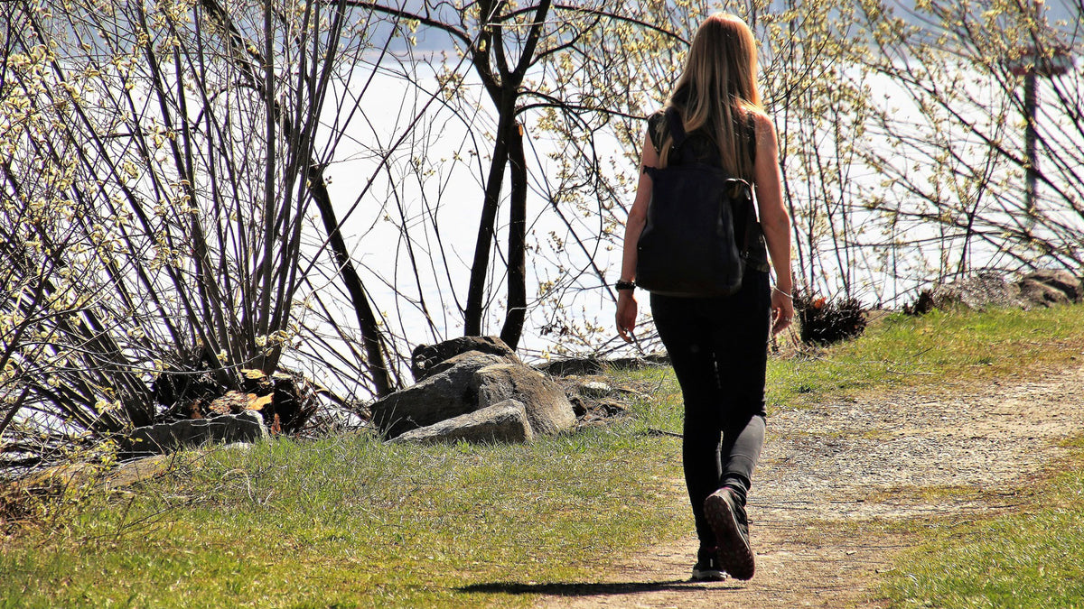 Lady walking in the spring sun next to a lake