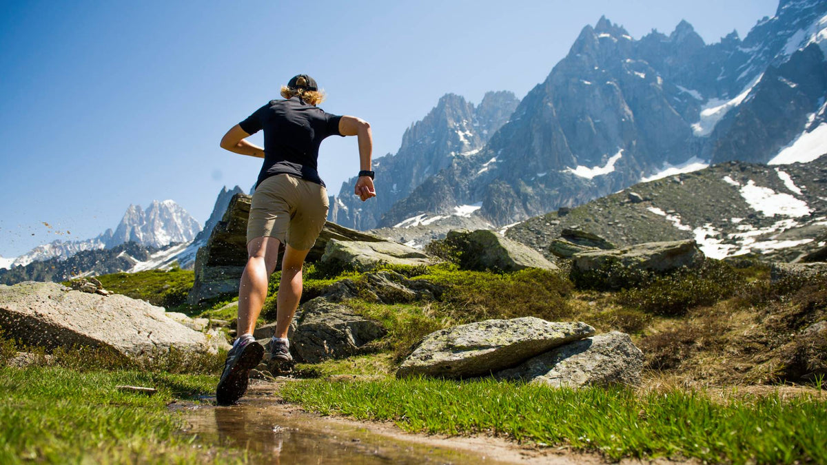 Woman wearing a SuB Zero Factor 1 plus short sleeve thermal base layer in black whilst running in the mountains