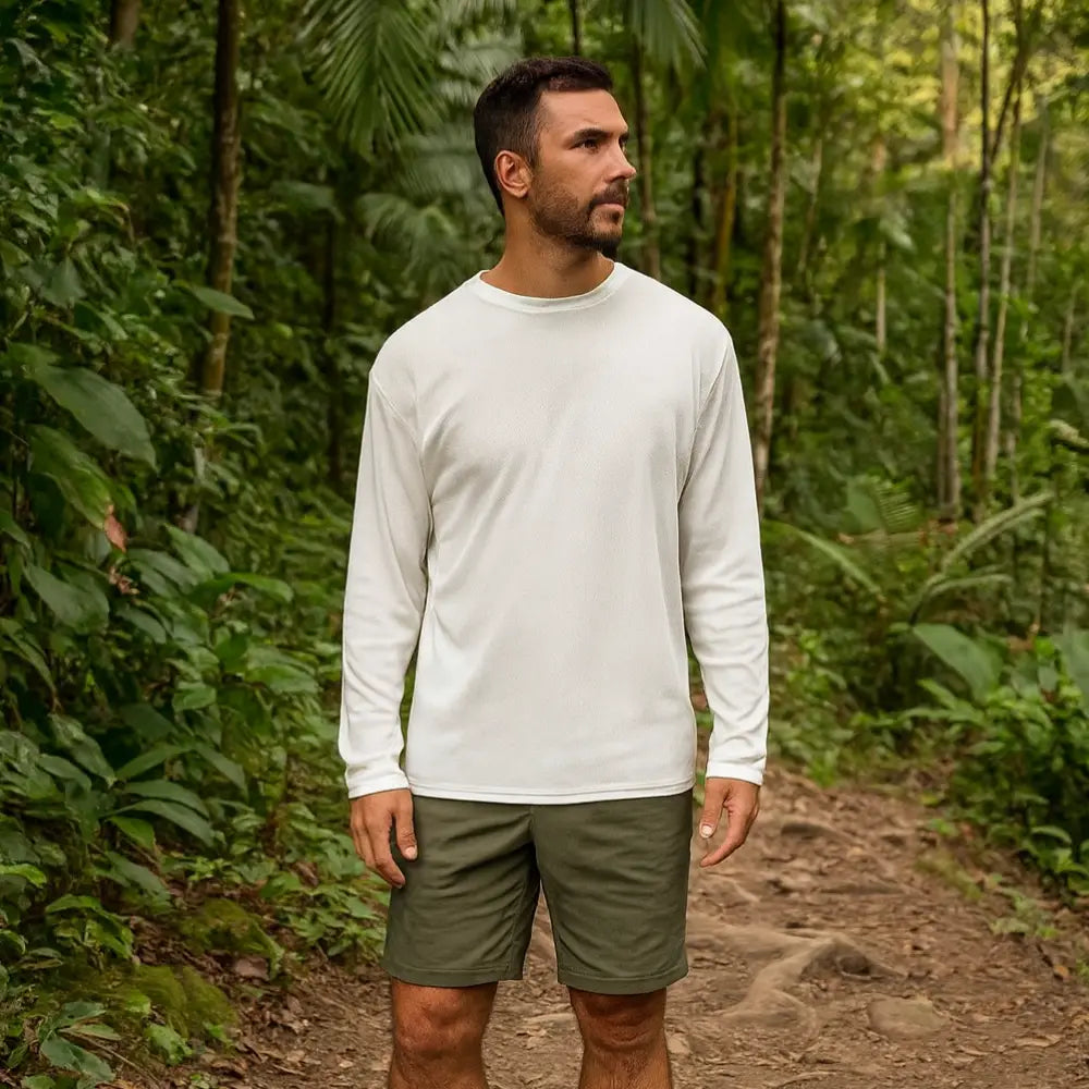 Man wearing a white Sub Zero Cool T wicking long-sleeve shirt and green trek shorts standing on a forest path.