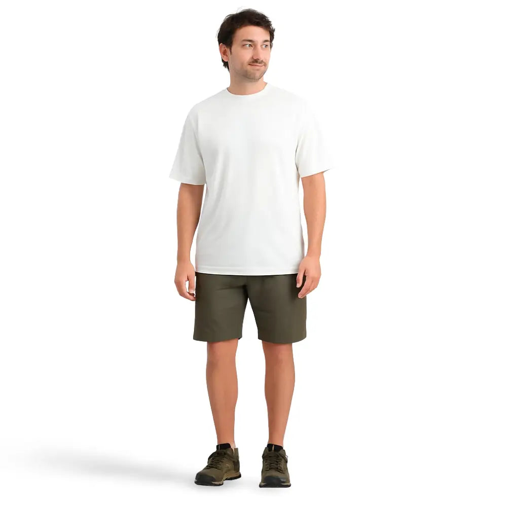 Man wearing an untucked white Sub Zero Cool T Wicking top and green shorts on a white background