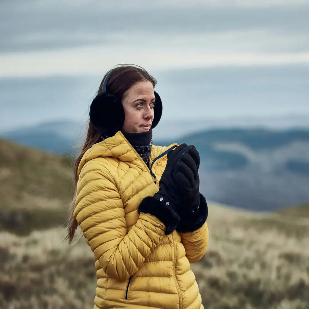 Lifestyle image of a woman wearing a pair of Extremities Chamonix waterproof gloves in the winter outdoors on a heath