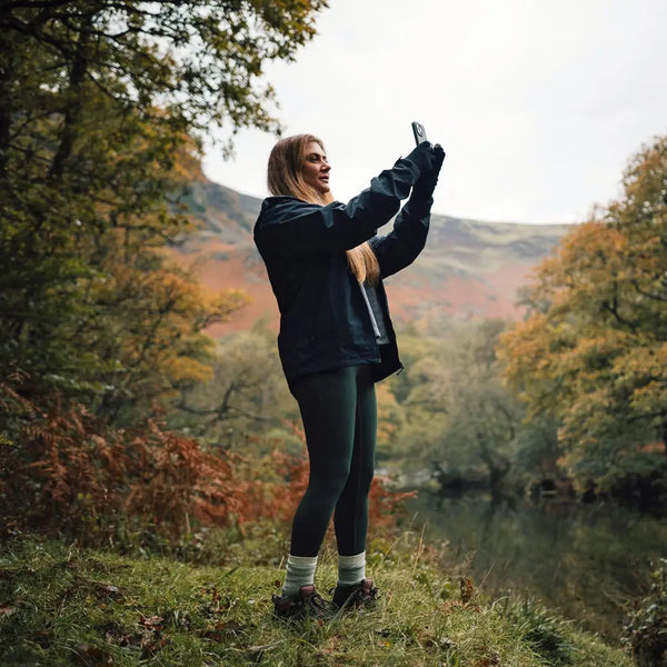 Woman wearing a pair of Extremities fingerless touchscreen gloves outdoors whilst taking a selfie