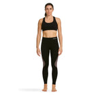 Woman wearing black athletic sports top and Sub Zero Factor 1 Plus stretch base layer leggings in black and pink on a white background