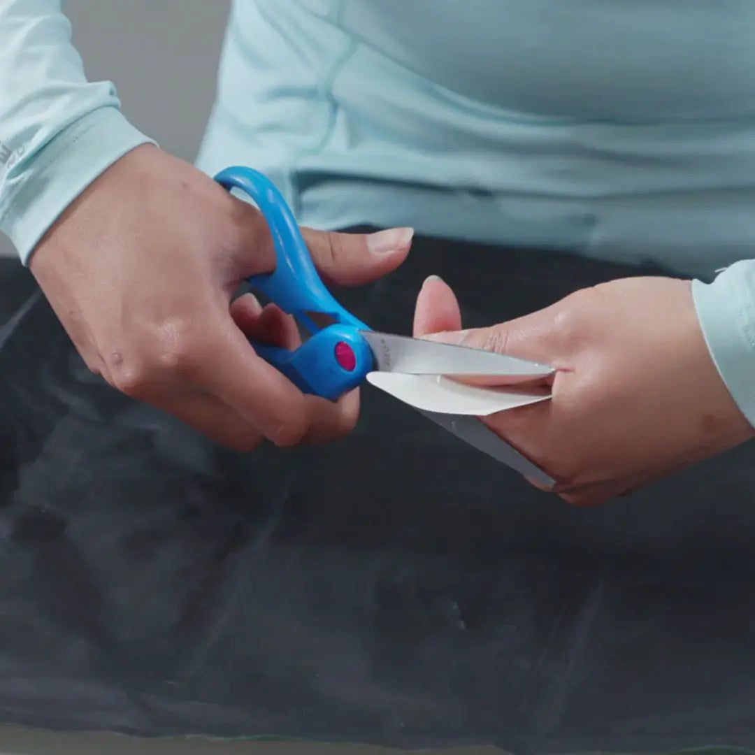 Gear Aid Tenacious flex patches being cut to shape and size with hand scissors