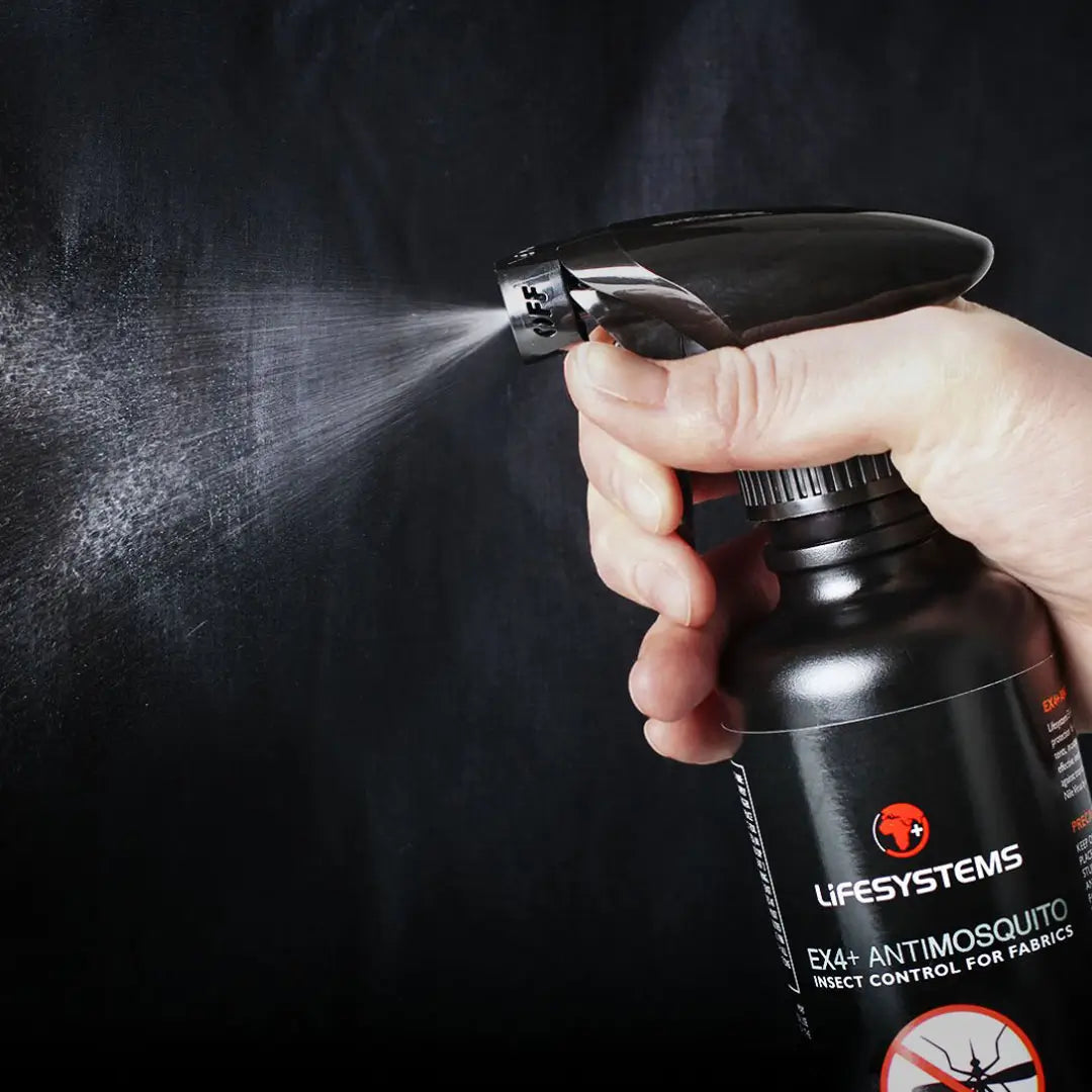 Person spraying Lifesystems EX4 Insect Repellent from its 350ml bottle against a dark background
