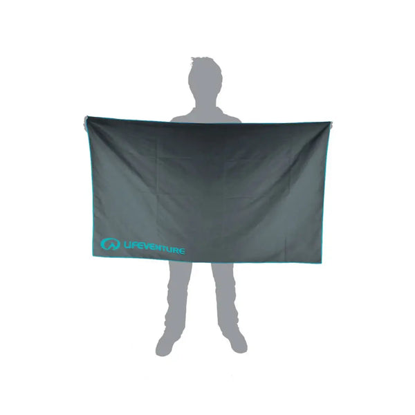 Pictorial image showing the relative size of a Lifeventure SoftFibre recycled travel towel in giant grey in comparison to a person