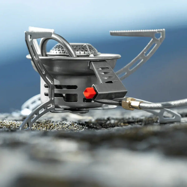 Primus Easy Fuel Duo Valve Camping Gas Stove showing the piezo ignition system on a blurred natural background