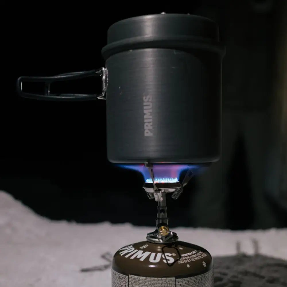 Primus Litech trek kettle ontop of a lit portable gas camping stoive in the snow