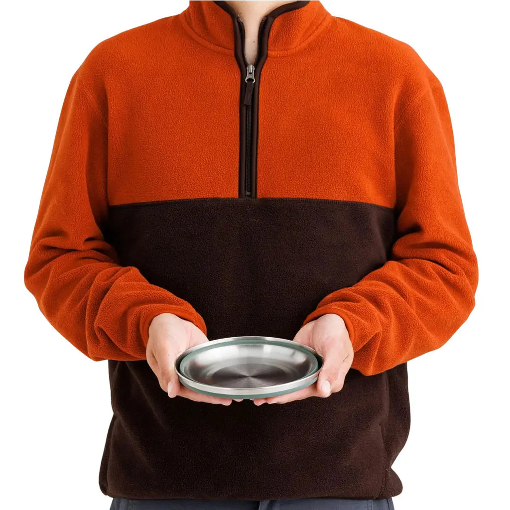 Person holding a fully collapsed Sea To Summit Detour Stainless Steel Collapsible Bowl in green colour to show the size equivalence