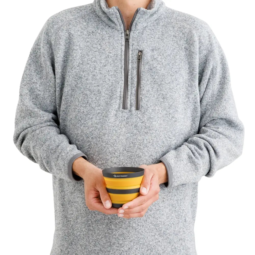 Person holding a Sea To Summit Frontier Collapsible Cup 400ml in their hands to show the relative size 