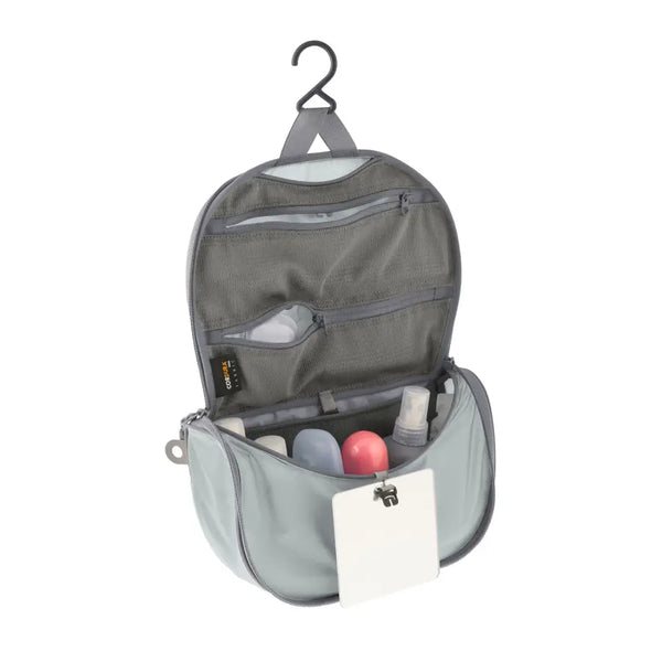 Sea To Summit small Hanging Toiletry Bag in grey with the hanging lid flap unzipped on a white background