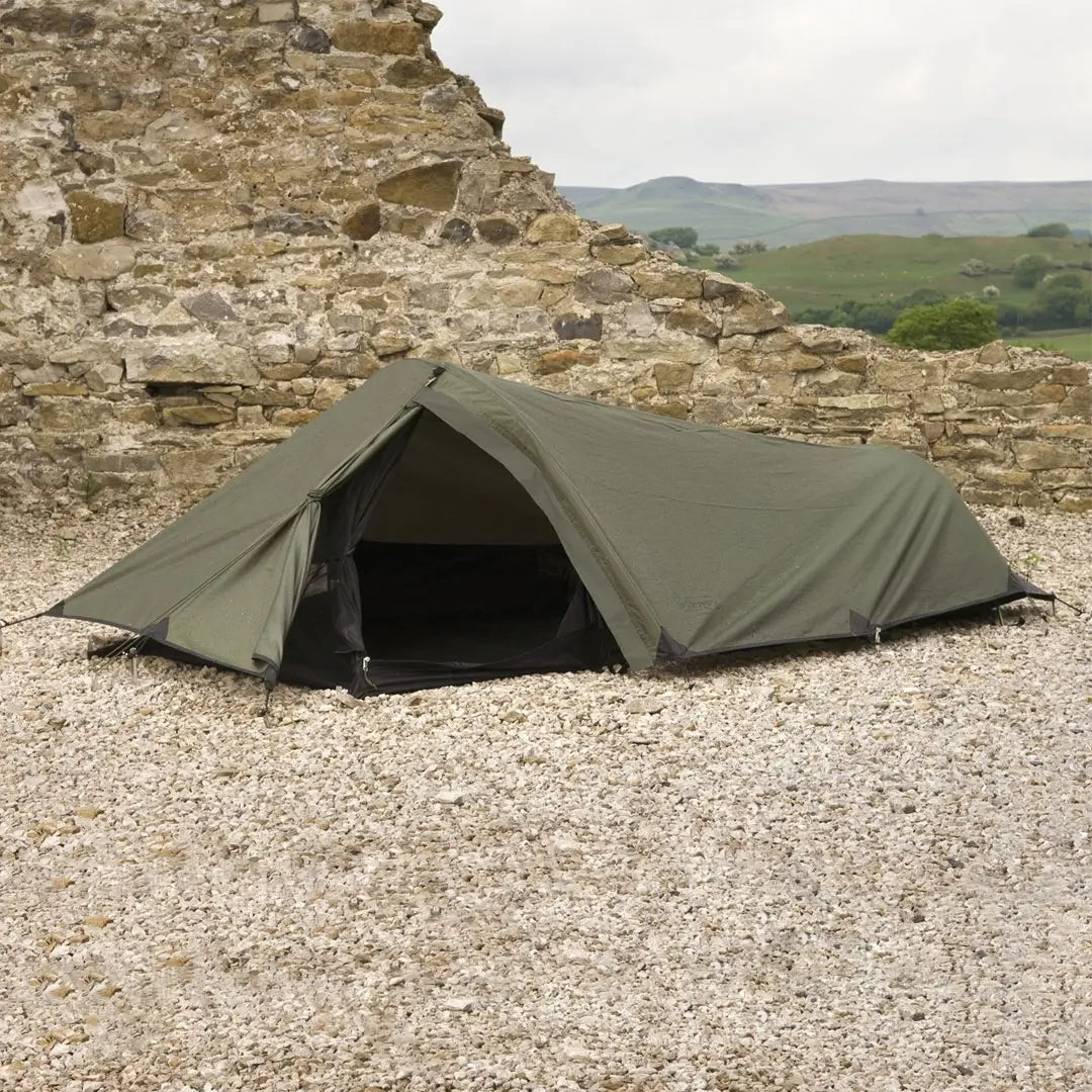 Lifestyle shot of Snugpaks Ionosphere tent pitched outdoors in front of a stone wall