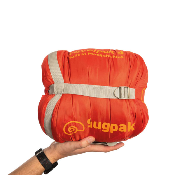 Snugpak Travelpak 4 sleeping bag packed in to its stuff sack and compressed using the straps being held in someones palm for a size comparison