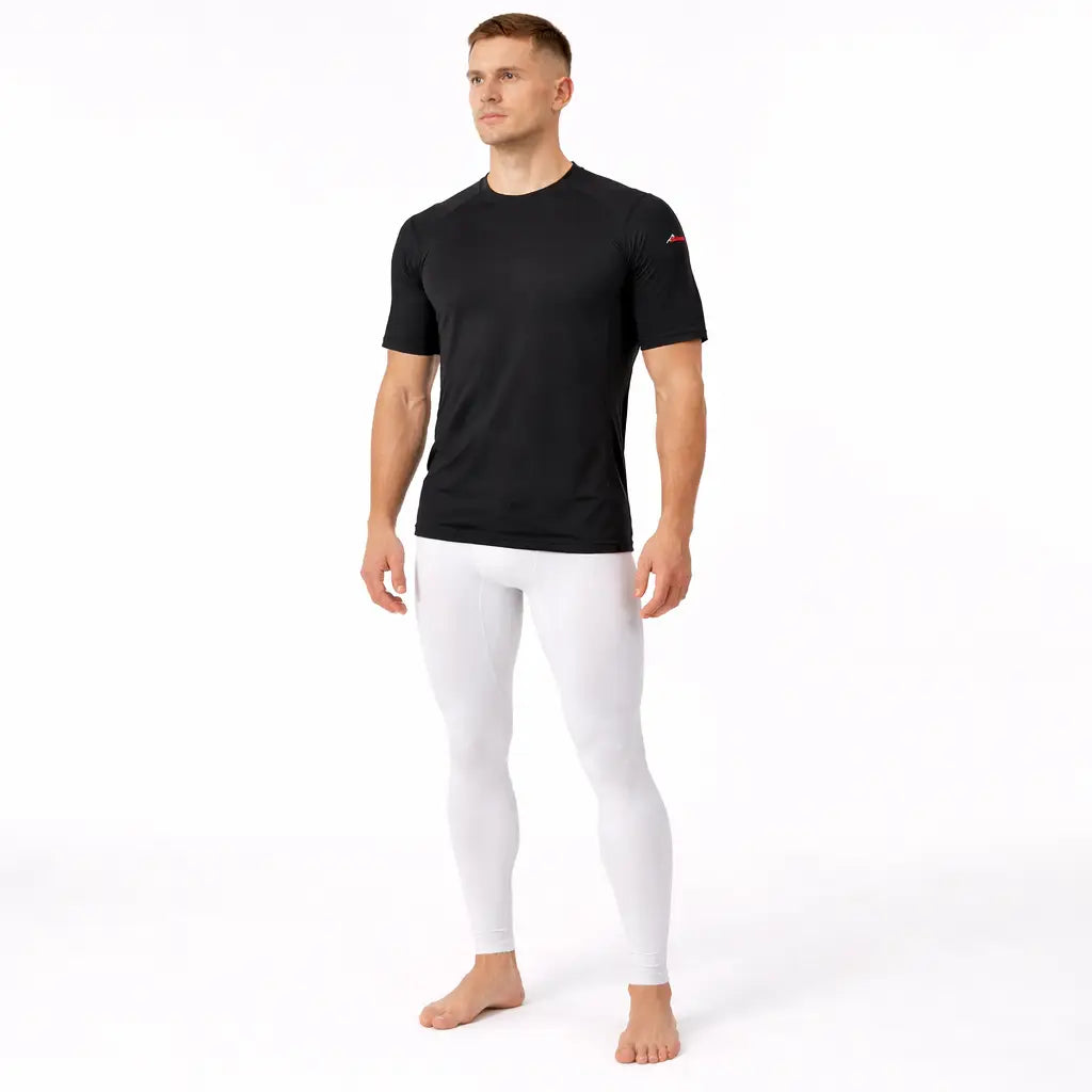 Man wearing a Sub Zero Factor 2 mens short sleeve thermal mid layer top in black with white base layer leggings on a white background 