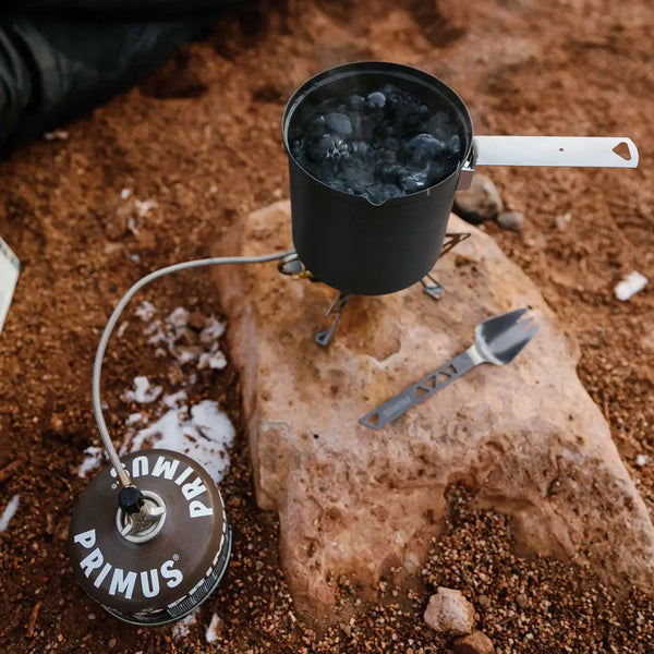 Primus Winter gas being used with a stove to melt snow for a hot winters drink outdoors