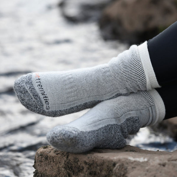 Lifestyle photograph of a pair of Extremities Merino Wool Mountain Toester Socks being worn outside next to a stream