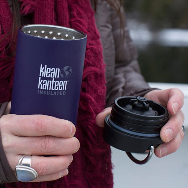 A woman holding a Klean Kanteen TKWide Cafe Cap after unscrewing it form her thermal mug