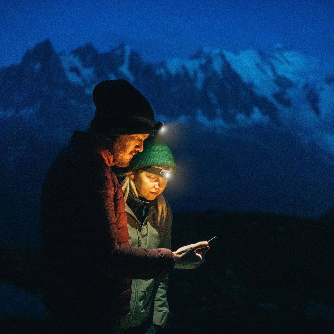 Lifestyle shot of two people outdoors in winter reading using NEBO Mycro rechargeable LED head torches