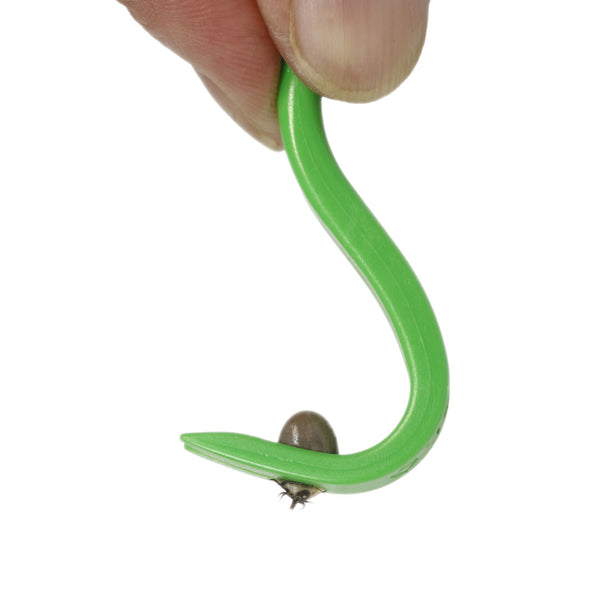 Plastic tick remover held by someones fingers showing a tick being held in the pincers