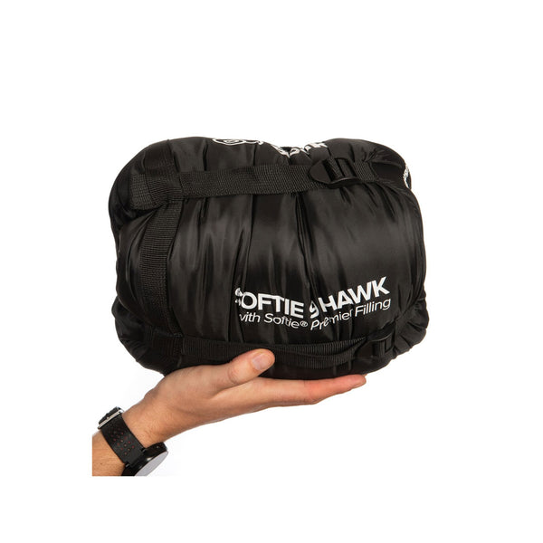 Snugpak Softie 9 Hawk in black packed in its stuff sack and compressed using the sacks strapping whilst being held in the palm of someones hand for size comparison